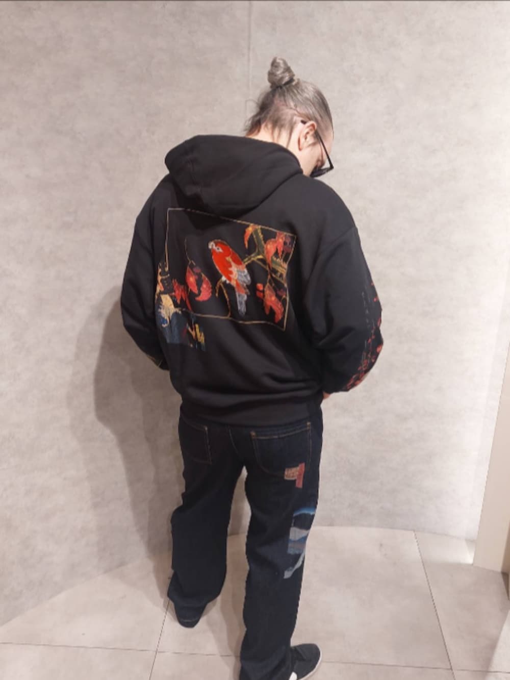 ブラック系のスウェット、ブルー系のデニムパンツ、ブラック系のシューズを着用したメンズの秋コーディネートの2枚目の写真