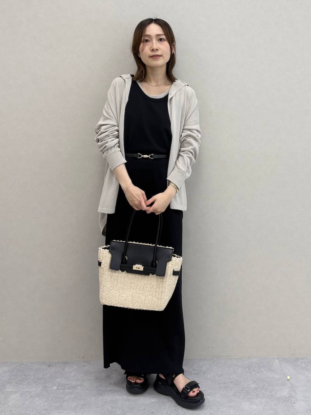 ベージュ系のTシャツ/カットソー、ブラック系のワンピース、ベージュ系のかごバッグを着用したレディースの春コーディネートの7枚目の写真