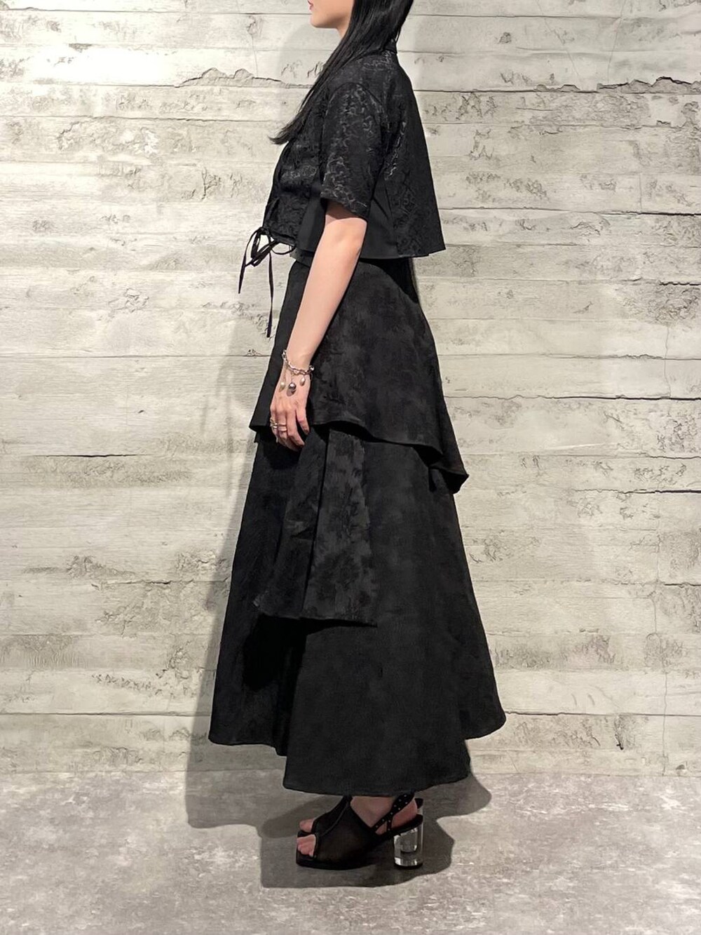 ブラック系のサンダル、ブラック系のシャツ/ブラウス、ブラック系のスカートを着用したレディースの夏コーディネートの2枚目の写真