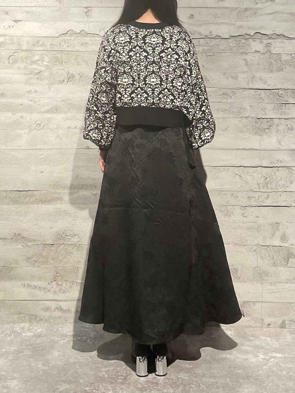 ブラック系のブーツ、ブラック系のニット/セーター、ブラック系のスカートを着用したレディースの秋コーディネートの3枚目の写真