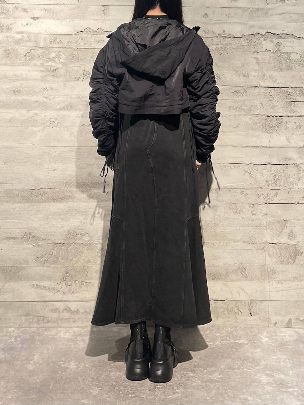 ブラック系のブーツ、ブラック系のニット/セーター、ブラック系のスカートを着用したレディースの秋コーディネートの3枚目の写真