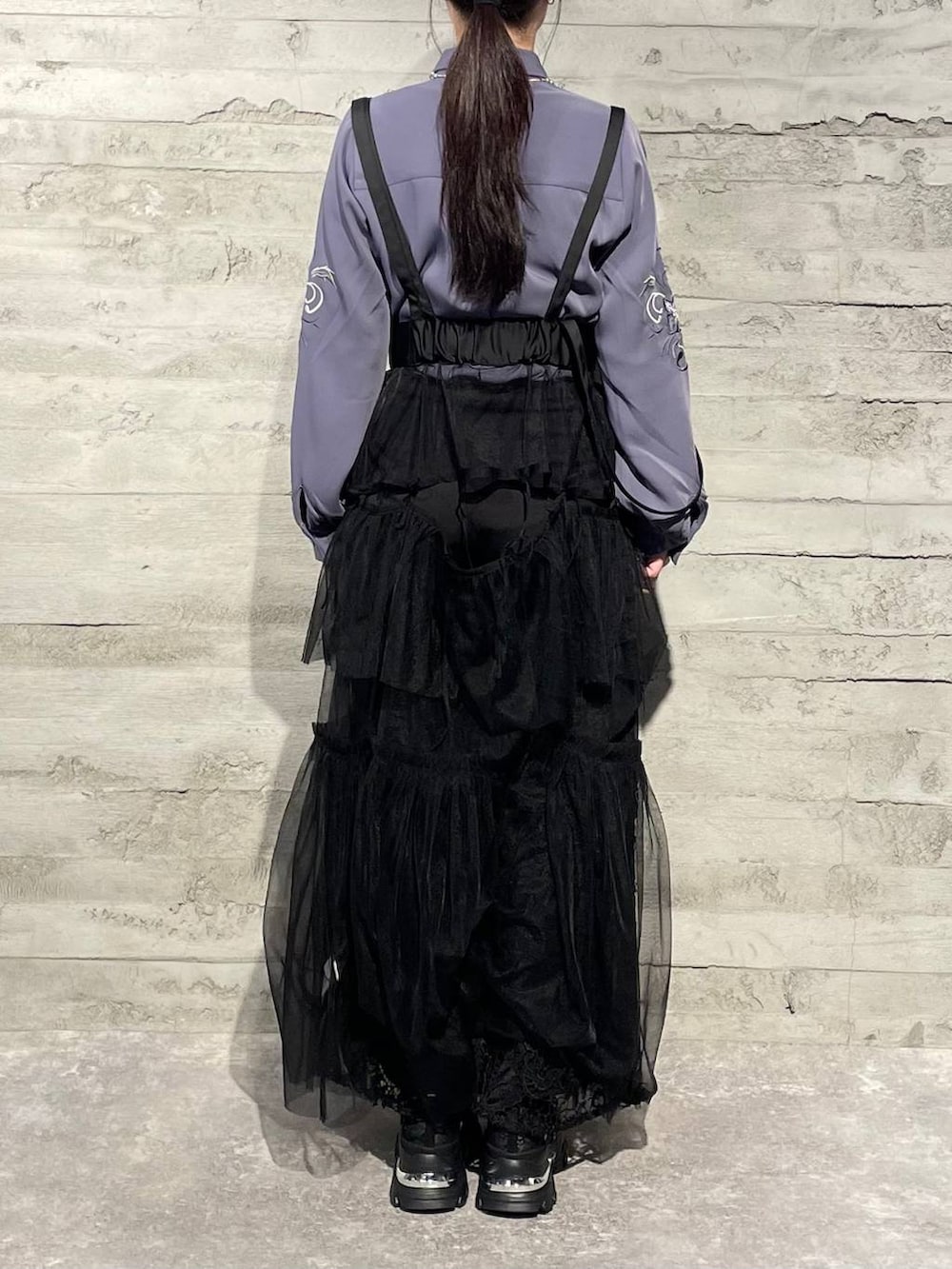 ブラック系のネクタイ、ブラック系のスカート、ブラック系のスニーカーを着用したレディースの冬コーディネートの3枚目の写真