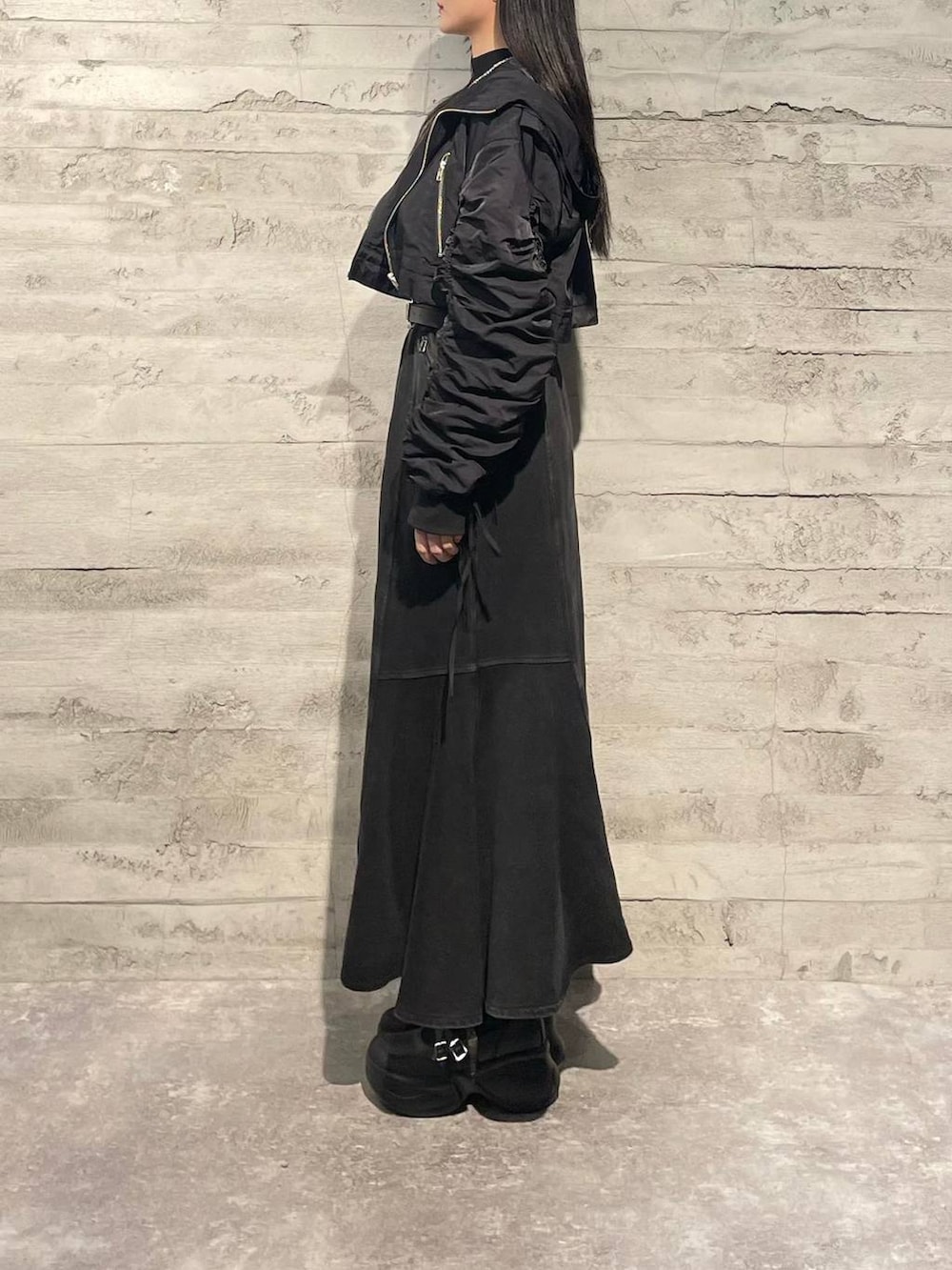 ブラック系のブーツ、ブラック系のニット/セーター、ブラック系のスカートを着用したレディースの秋コーディネートの2枚目の写真