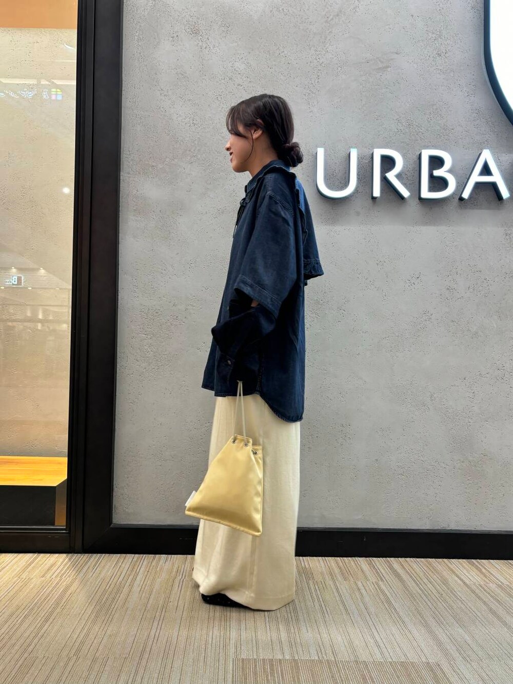 ホワイト系のスカート、ブラック系のシャツ/ブラウス、イエロー系のショルダーバッグを着用したレディースの夏コーディネートの2枚目の写真