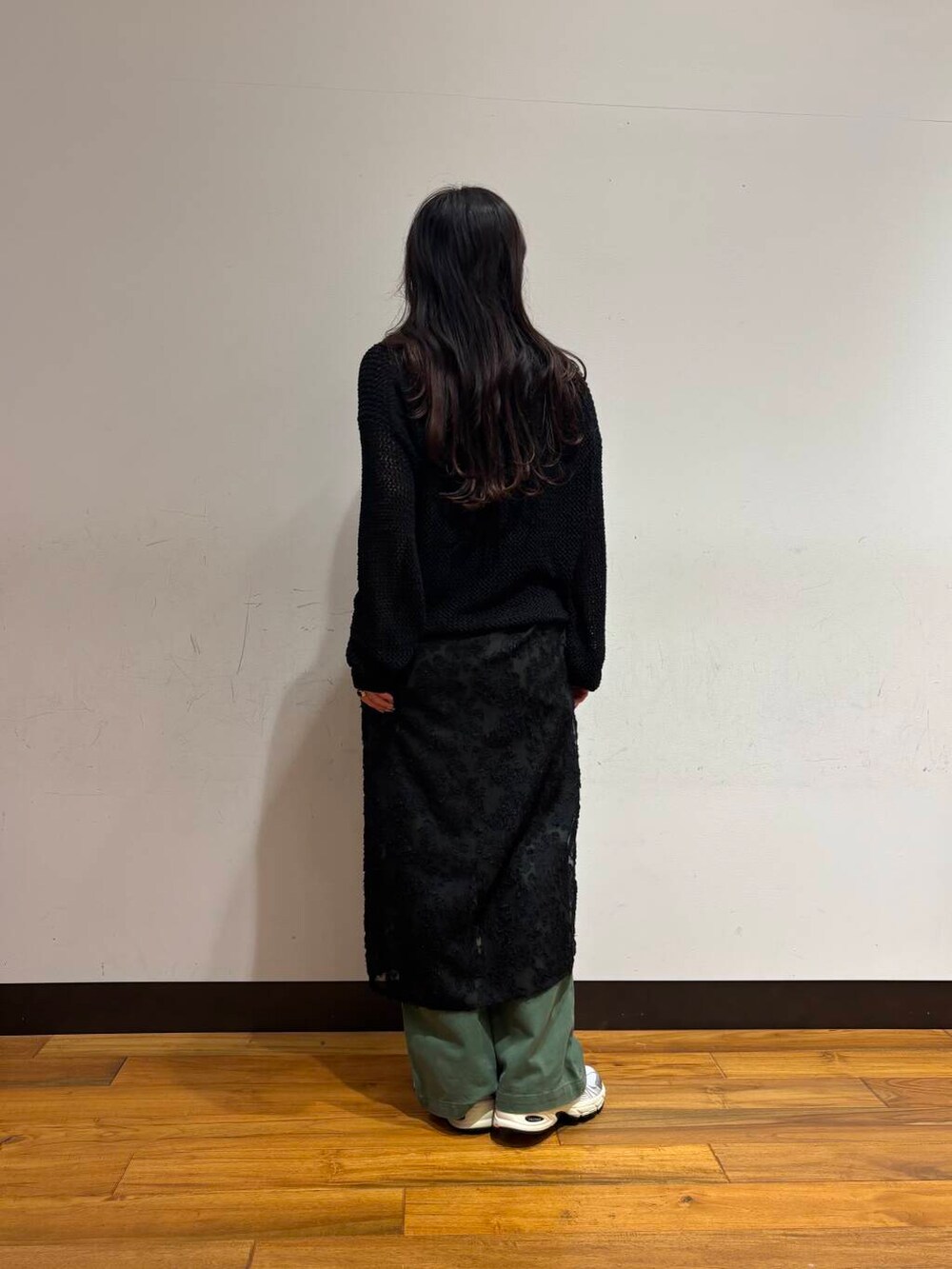 グリーン系のその他パンツ、シルバー系のスニーカー、ブラック系のニット/セーターを着用したレディースの春コーディネートの3枚目の写真