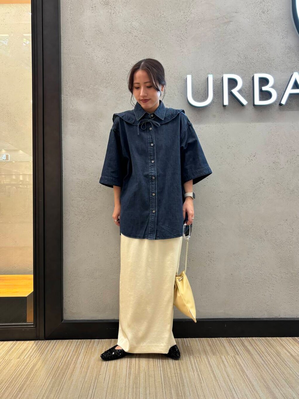 ホワイト系のスカート、ブラック系のシャツ/ブラウス、イエロー系のショルダーバッグを着用したレディースの夏コーディネートの4枚目の写真