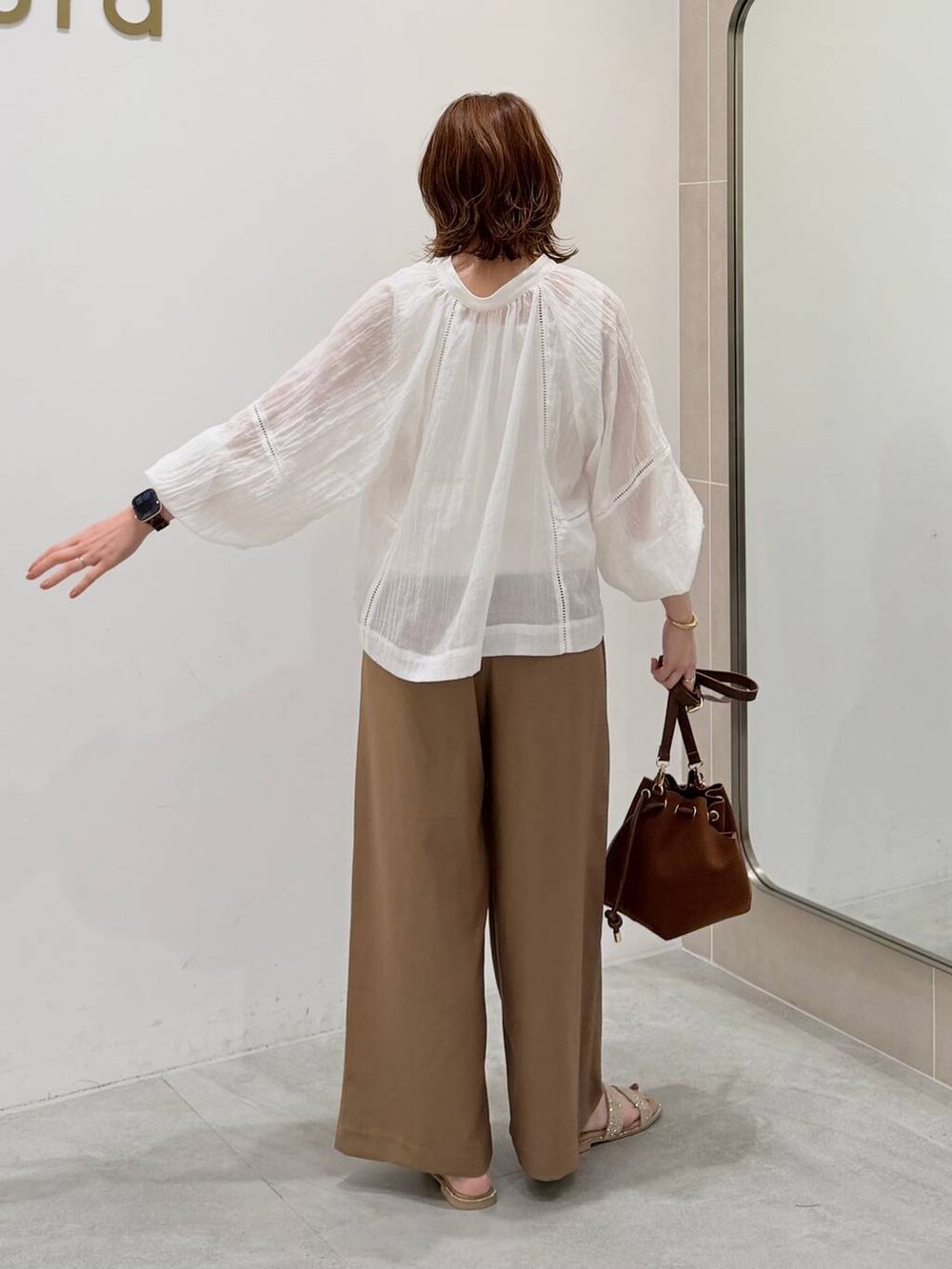 ホワイト系のTシャツ/カットソー、ブラウン系のハンドバッグ、イエロー系のその他パンツを着用したレディースの夏コーディネートの3枚目の写真