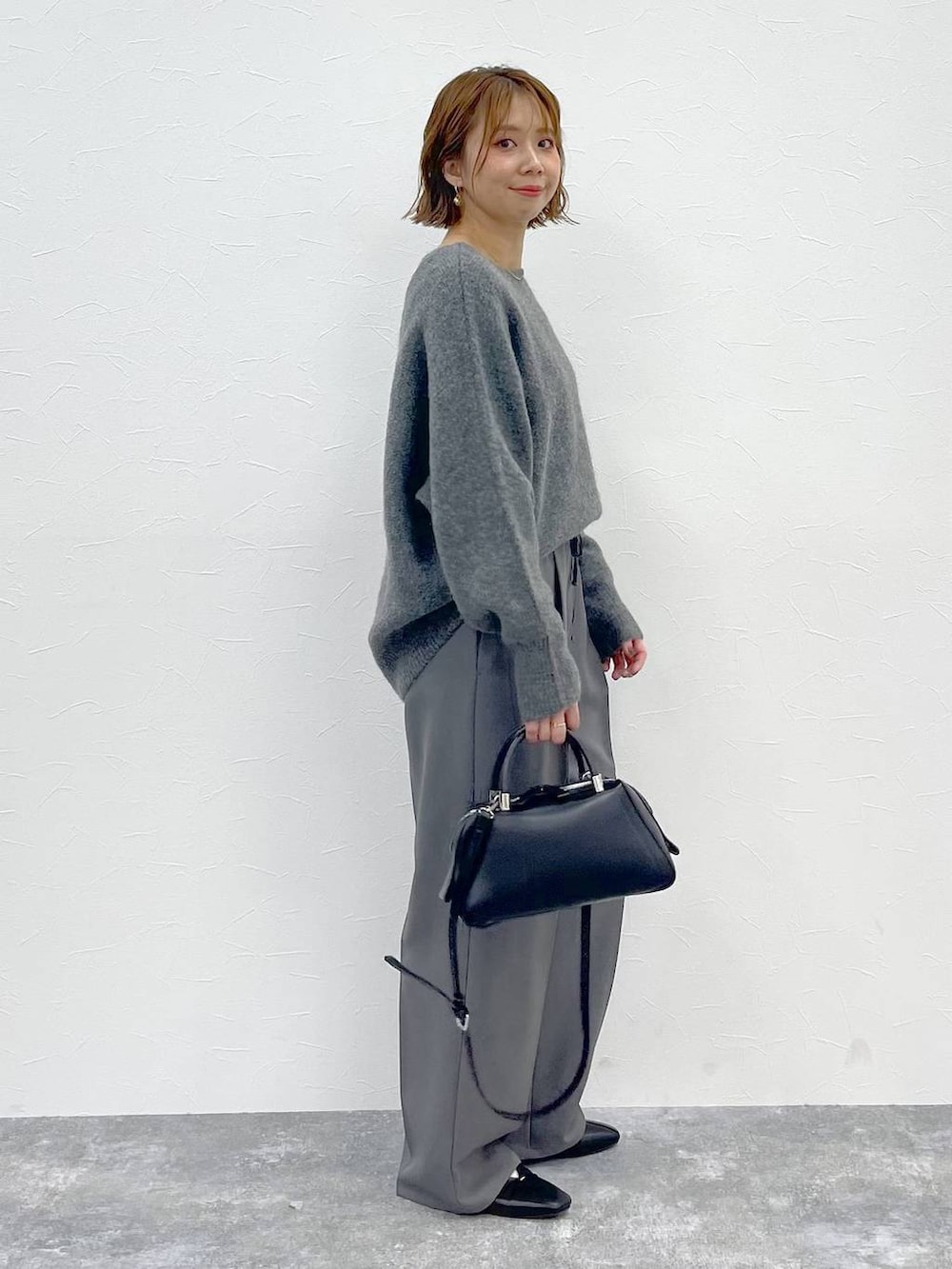 グレー系のその他パンツ、グレー系のニット/セーター、ブラック系のパンプスを着用したレディースの秋コーディネートの4枚目の写真