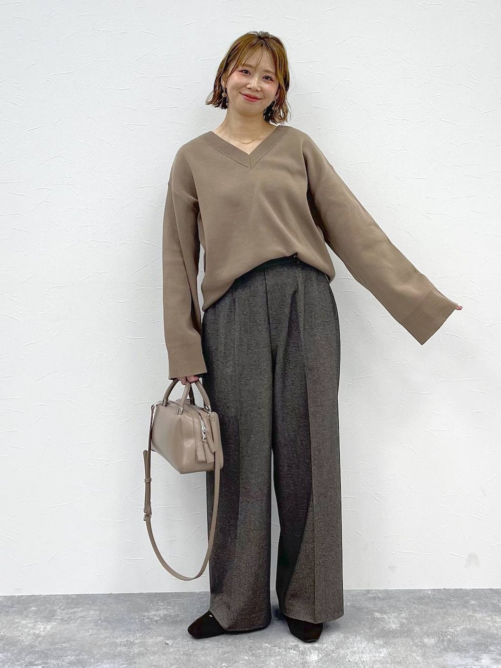 ベージュ系のニット/セーター、ブラウン系のその他パンツ、ブラウン系のパンプスを着用したレディースの秋コーディネートの5枚目の写真