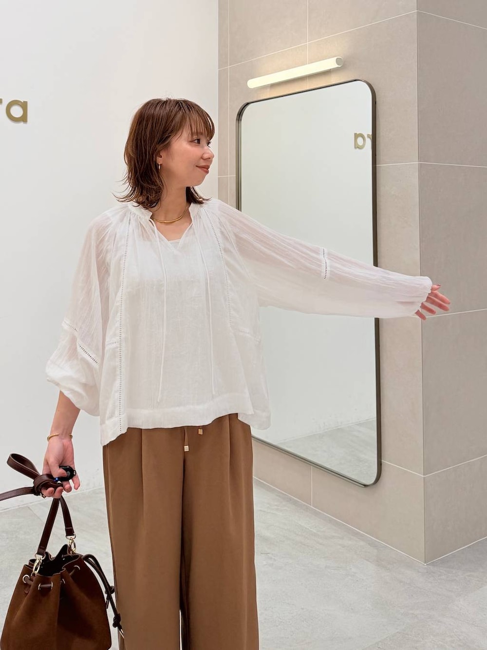 ホワイト系のTシャツ/カットソー、ブラウン系のハンドバッグ、イエロー系のその他パンツを着用したレディースの夏コーディネートの5枚目の写真