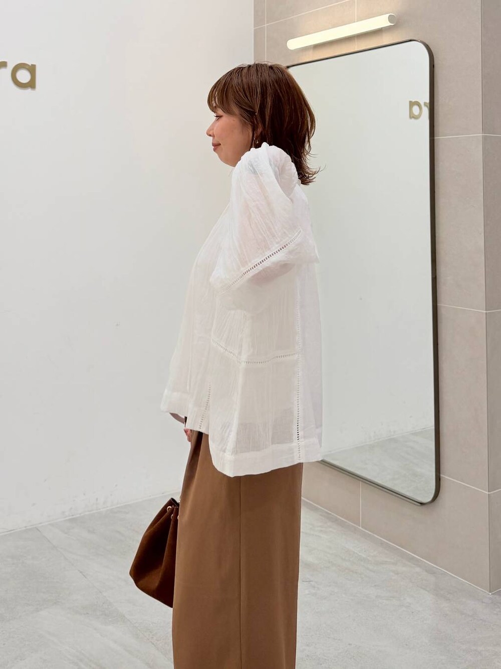 ホワイト系のTシャツ/カットソー、ブラウン系のハンドバッグ、イエロー系のその他パンツを着用したレディースの夏コーディネートの6枚目の写真