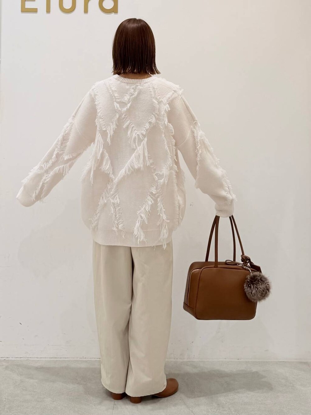 ブラウン系のブーツ、イエロー系のボストンバッグ、ホワイト系のその他パンツを着用したレディースの秋コーディネートの8枚目の写真