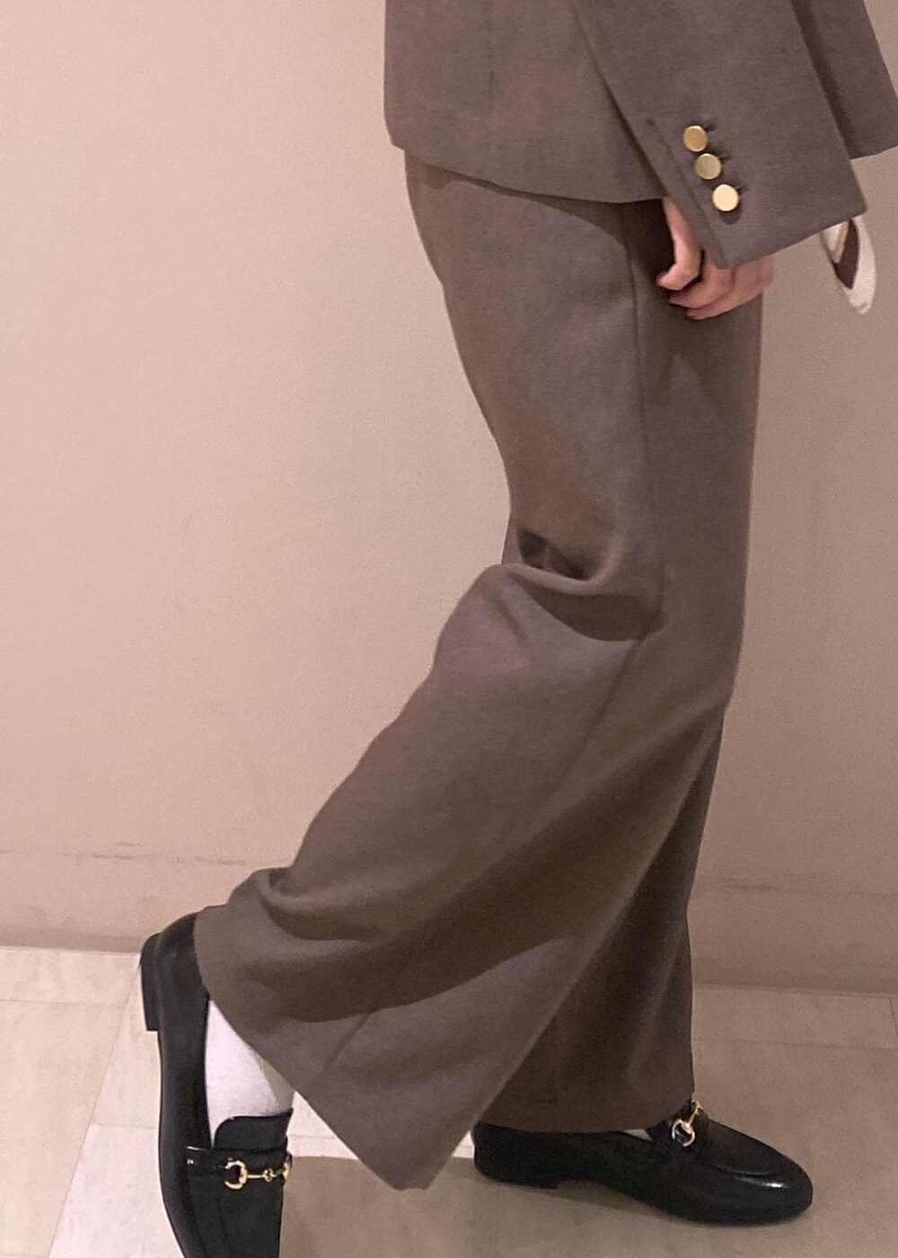 ベージュ系のTシャツ/カットソー、ベージュ系のスラックス、ベージュ系のテーラードジャケットを着用したレディースの秋コーディネートの5枚目の写真