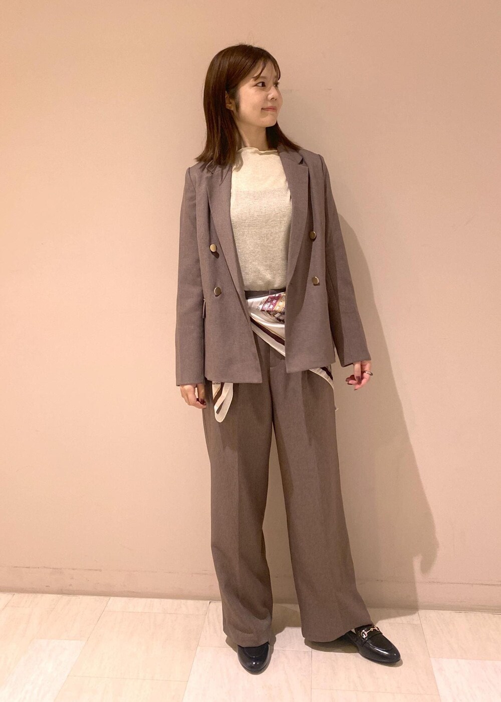 ベージュ系のTシャツ/カットソー、ベージュ系のスラックス、ベージュ系のテーラードジャケットを着用したレディースの秋コーディネートの3枚目の写真