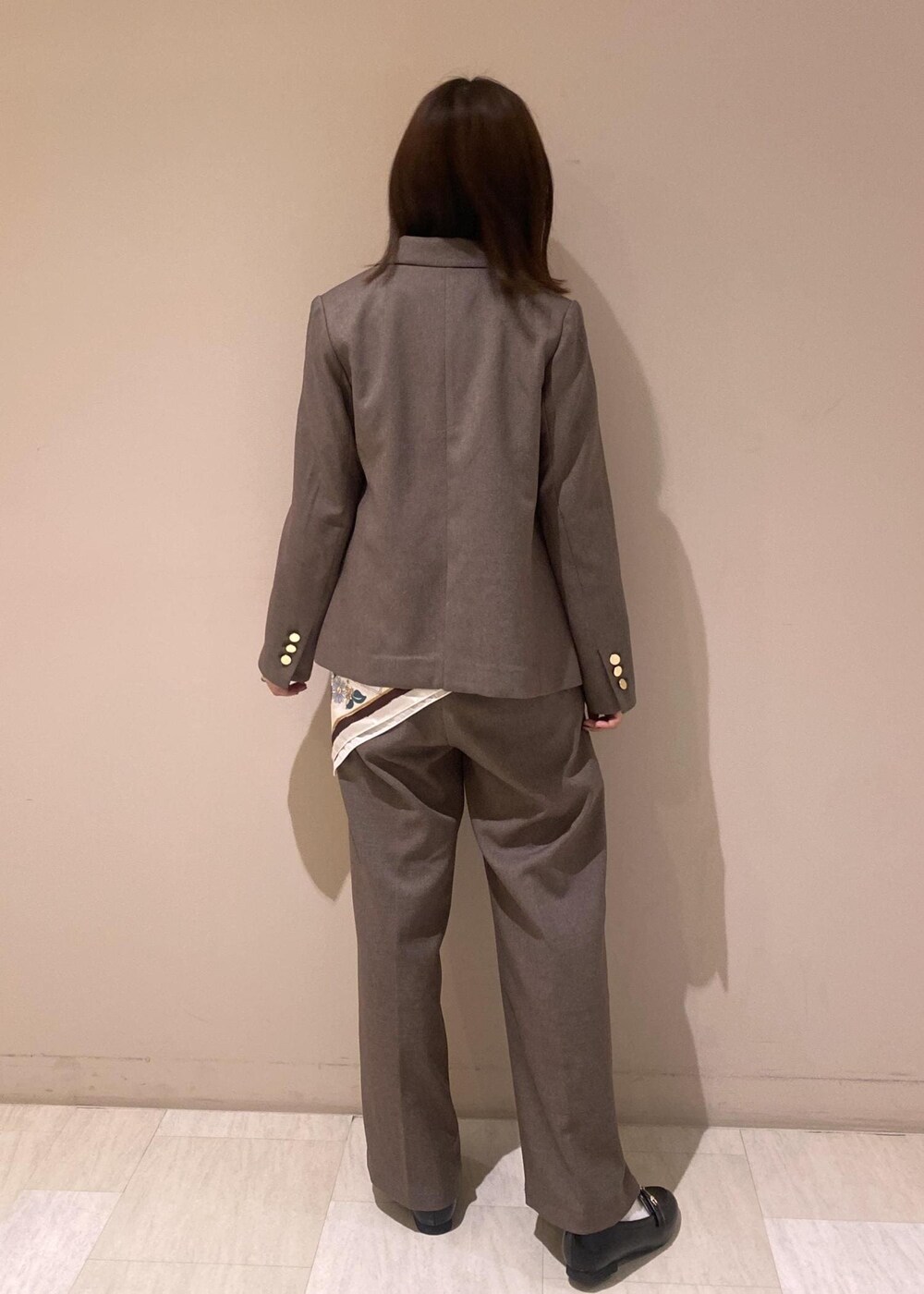 ベージュ系のTシャツ/カットソー、ベージュ系のスラックス、ベージュ系のテーラードジャケットを着用したレディースの秋コーディネートの4枚目の写真