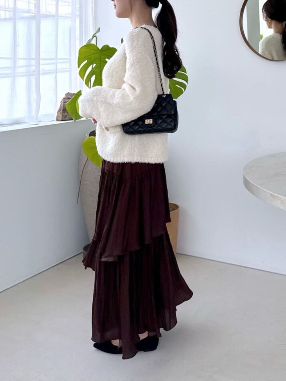 ホワイト系のキャミソール、ホワイト系のノーカラージャケット、ブラウン系のスカートを着用したレディースの秋コーディネートの4枚目の写真