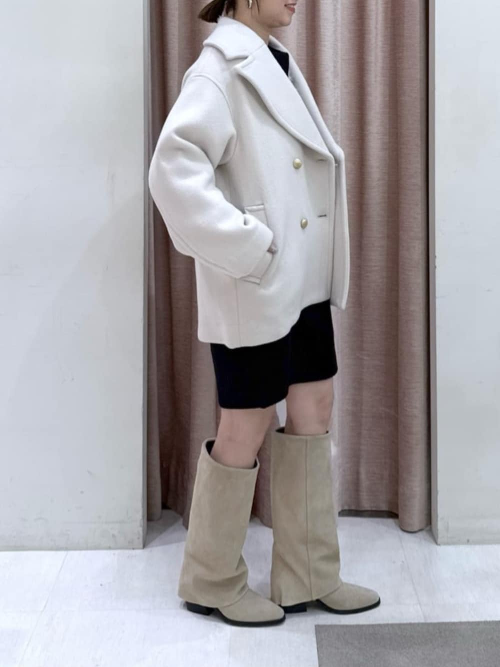 ホワイト系のトートバッグ、ブラック系のワンピース、ホワイト系のピーコートを着用したレディースの冬コーディネートの2枚目の写真