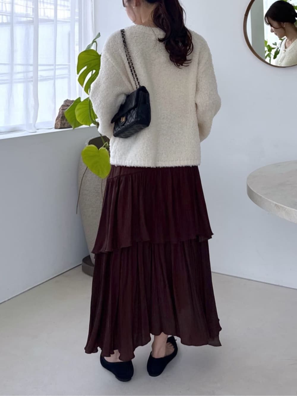 ホワイト系のキャミソール、ホワイト系のノーカラージャケット、ブラウン系のスカートを着用したレディースの秋コーディネートの3枚目の写真