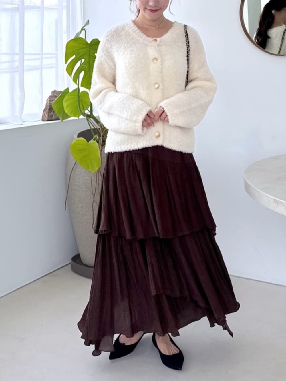 ホワイト系のキャミソール、ホワイト系のノーカラージャケット、ブラウン系のスカートを着用したレディースの秋コーディネートの5枚目の写真