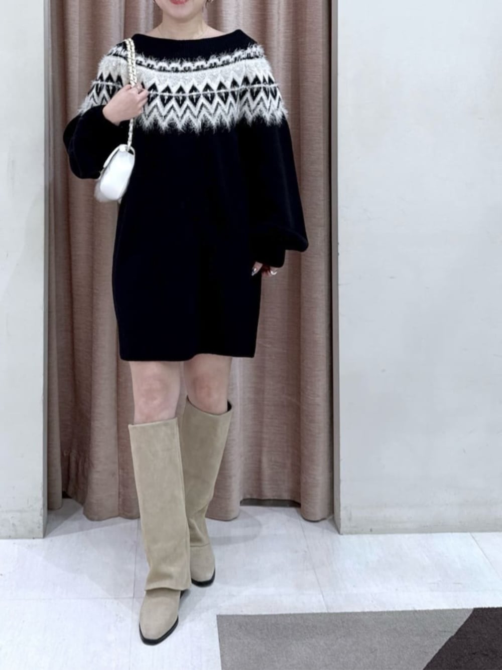 ホワイト系のトートバッグ、ブラック系のワンピース、ホワイト系のピーコートを着用したレディースの冬コーディネートの4枚目の写真