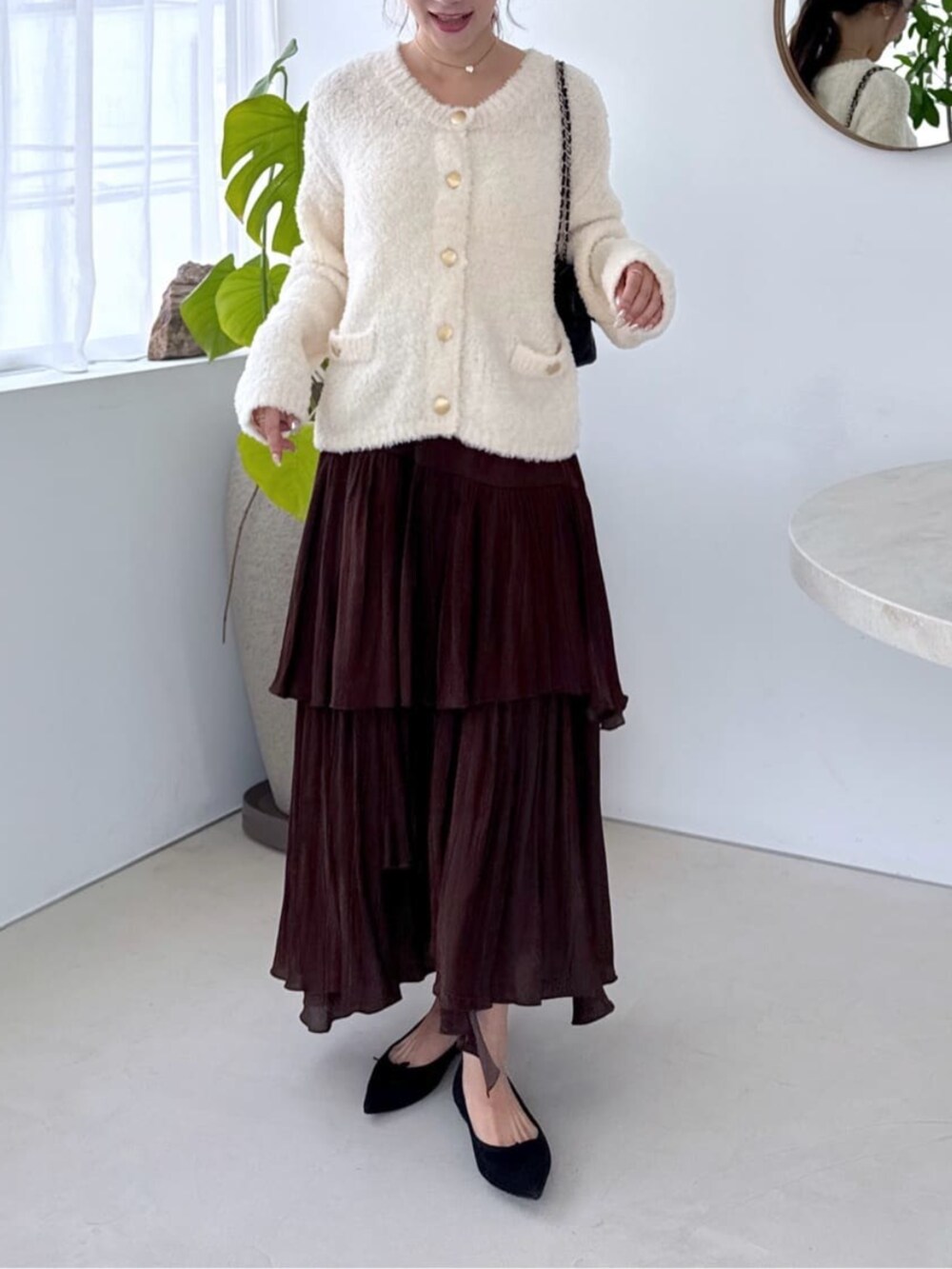 ホワイト系のキャミソール、ホワイト系のノーカラージャケット、ブラウン系のスカートを着用したレディースの秋コーディネートの2枚目の写真