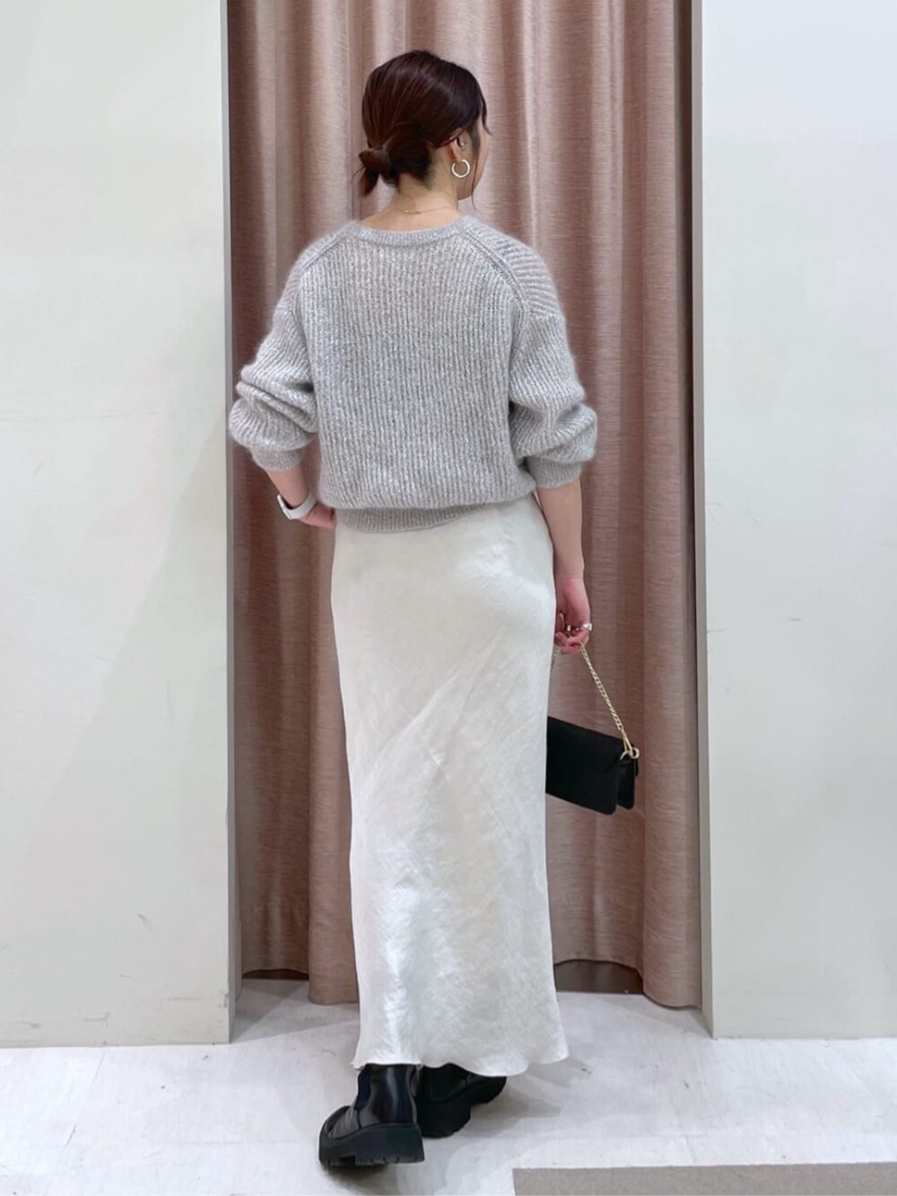 グレー系のスカート、シルバー系のニット/セーターを着用したレディースの秋コーディネートの3枚目の写真