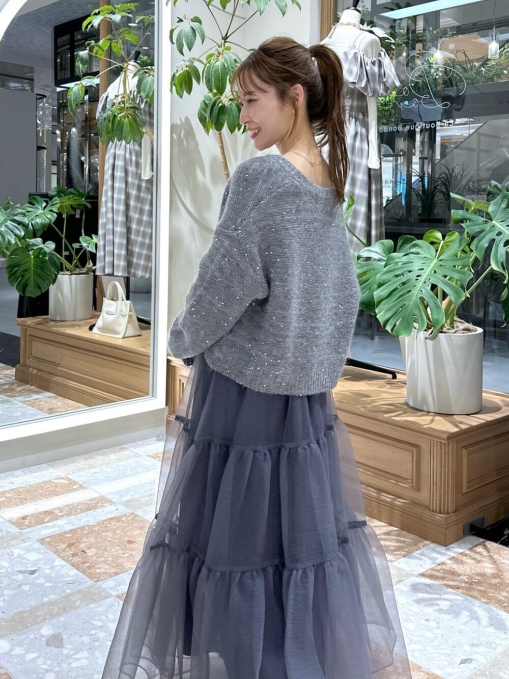 グレー系のニット/セーター、グレー系のカーディガン/ボレロ、グレー系のスカートを着用したレディースの秋コーディネートの7枚目の写真