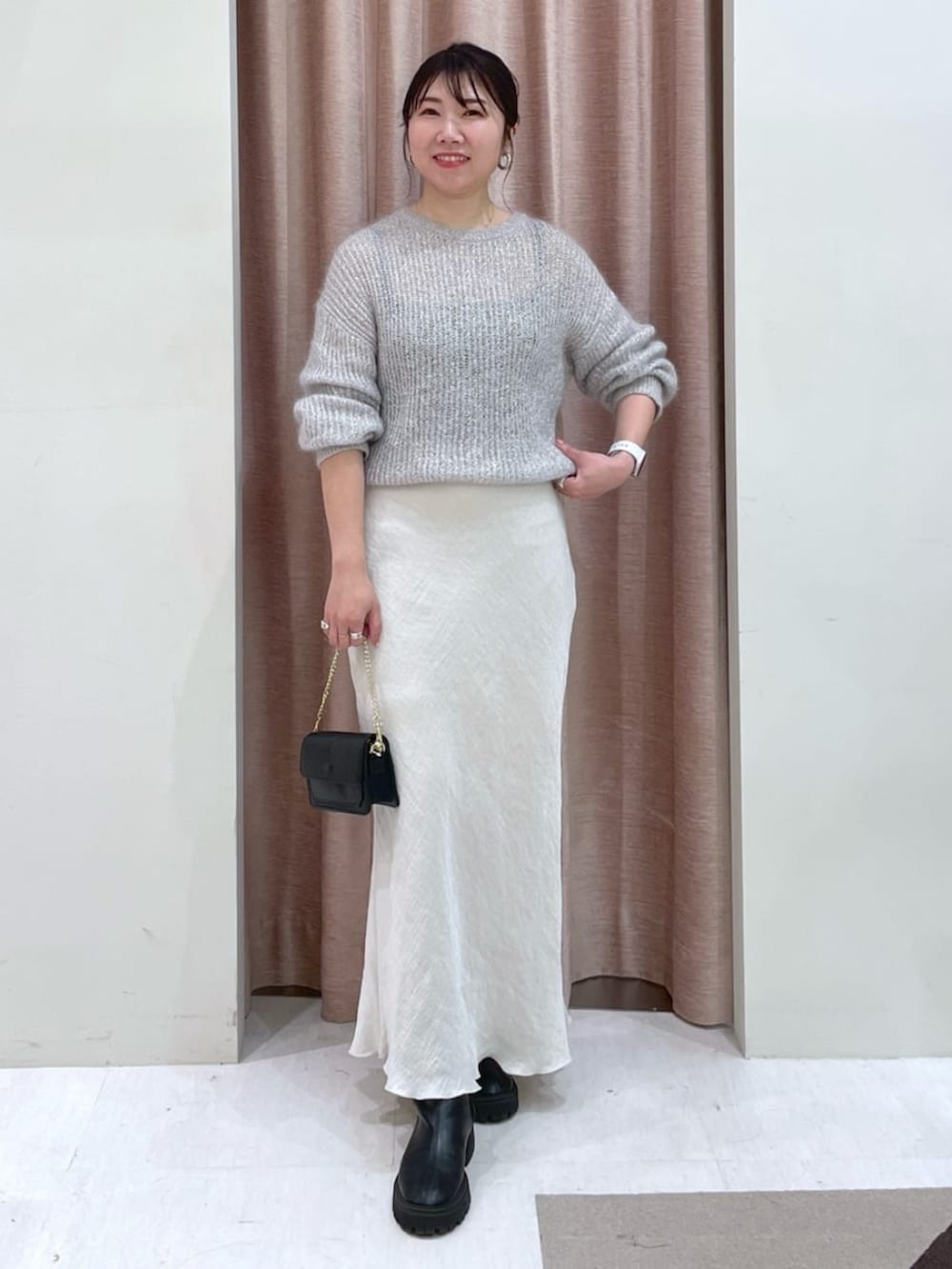 グレー系のスカート、シルバー系のニット/セーターを着用したレディースの秋コーディネートの5枚目の写真