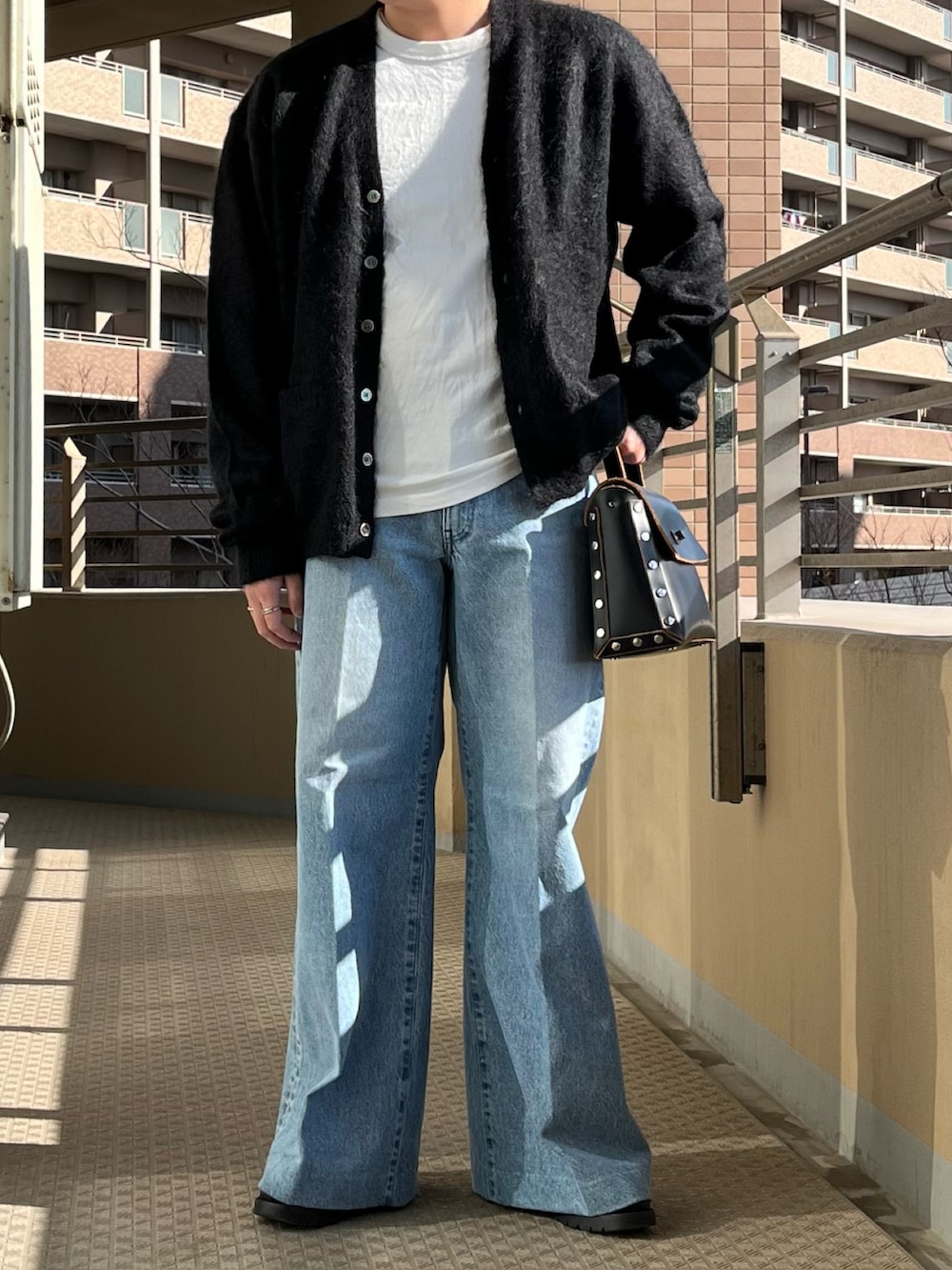 ブラック系のショルダーバッグ、ブルー系のデニムパンツ、ブラック系のカーディガン/ボレロを着用したメンズの冬コーディネートの4枚目の写真