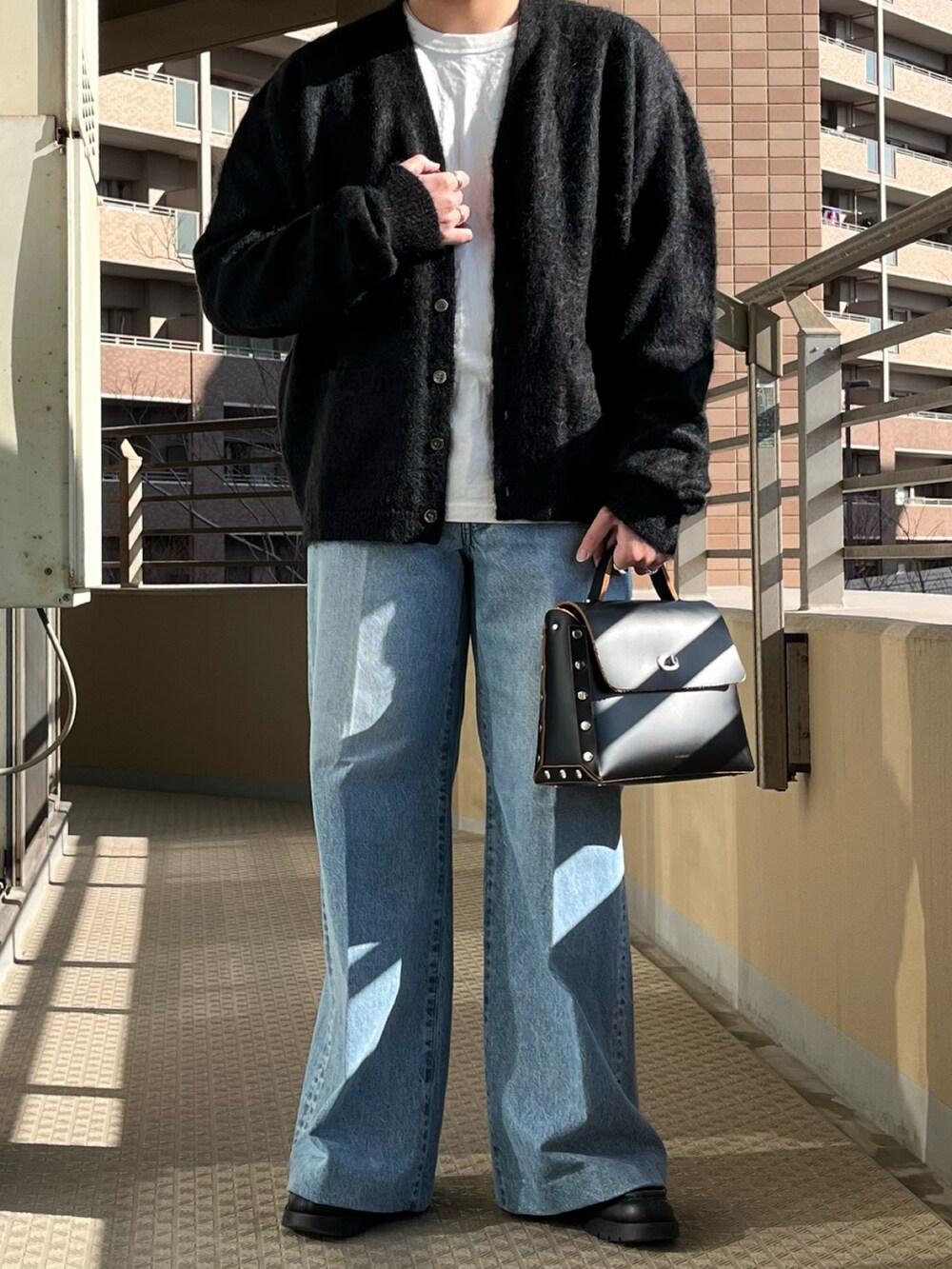 ブラック系のショルダーバッグ、ブルー系のデニムパンツ、ブラック系のカーディガン/ボレロを着用したメンズの冬コーディネートの3枚目の写真