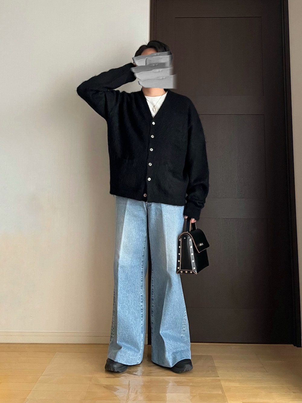 ブルー系のデニムパンツ、ブラック系のスニーカー、ブラック系のショルダーバッグを着用したメンズの春コーディネートの3枚目の写真