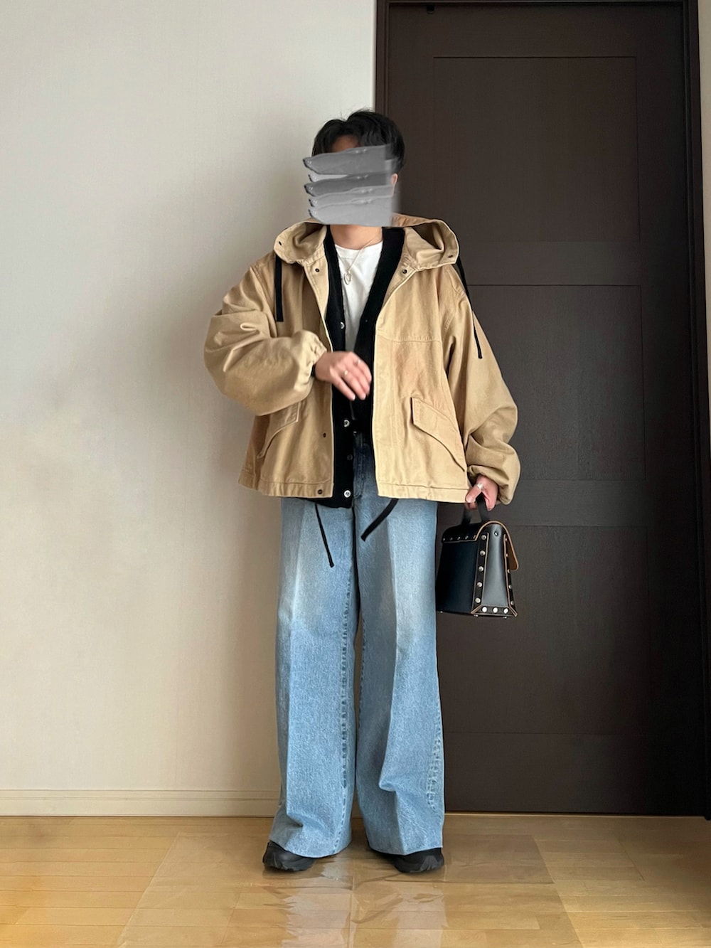 ブルー系のデニムパンツ、ブラック系のスニーカー、ブラック系のショルダーバッグを着用したメンズの春コーディネートの2枚目の写真