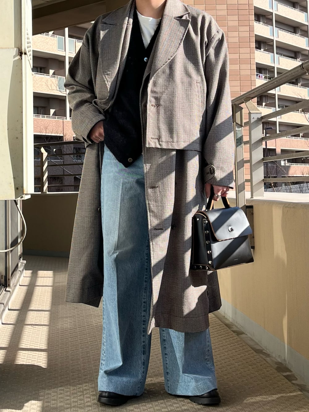 ブラック系のショルダーバッグ、ブルー系のデニムパンツ、ブラック系のカーディガン/ボレロを着用したメンズの冬コーディネートの2枚目の写真