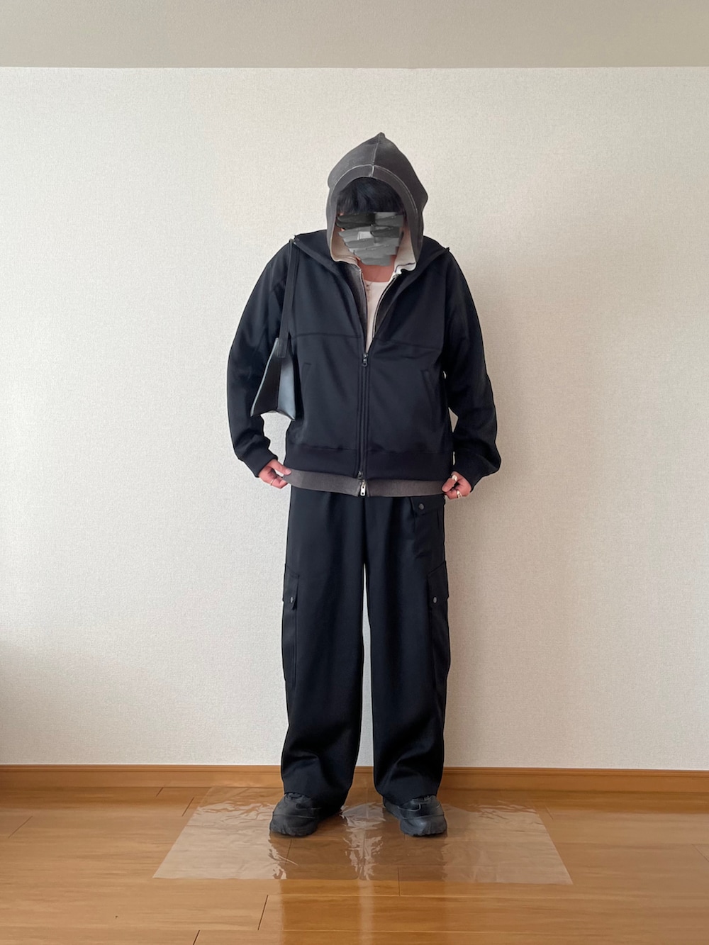 グレー系のパーカー、ブラック系のジャージ、ブラック系のカーゴパンツを着用したメンズの冬コーディネートの2枚目の写真