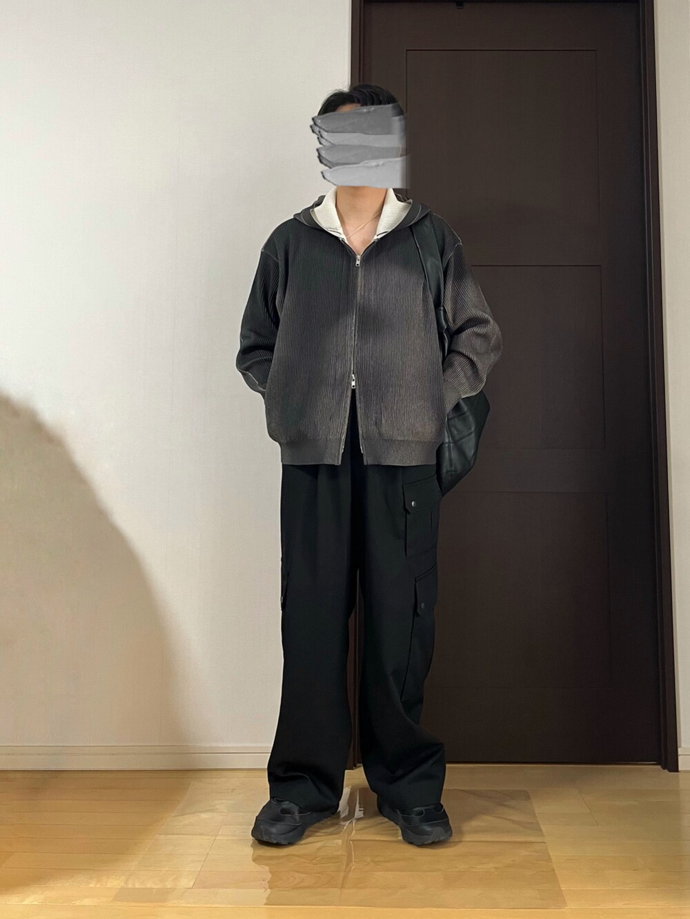 ブラック系のカーゴパンツ、ブラック系のスニーカー、グレー系のパーカーを着用したメンズの春コーディネートの2枚目の写真