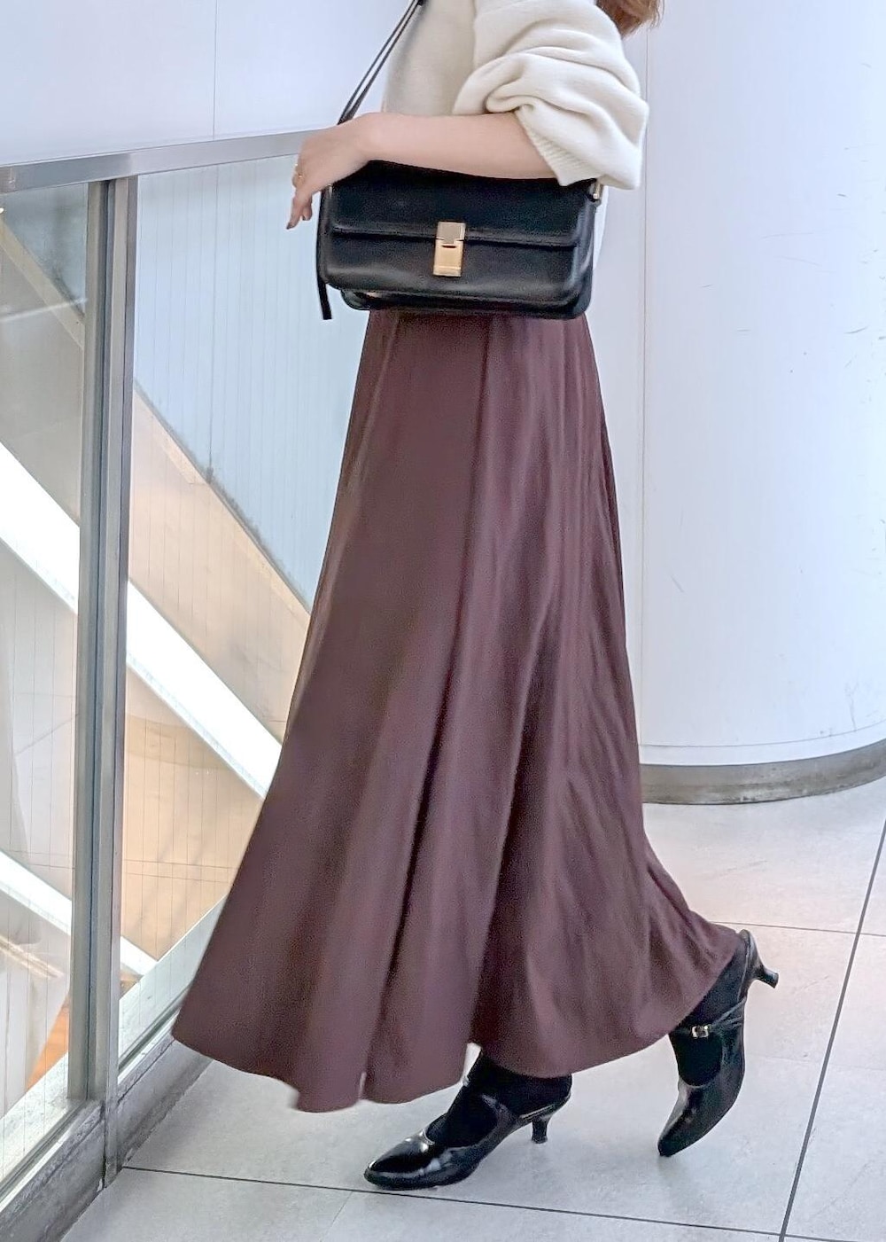 ブラック系のパンプス、ブラック系のショルダーバッグ、ホワイト系のカーディガン/ボレロを着用したレディースの秋コーディネートの4枚目の写真
