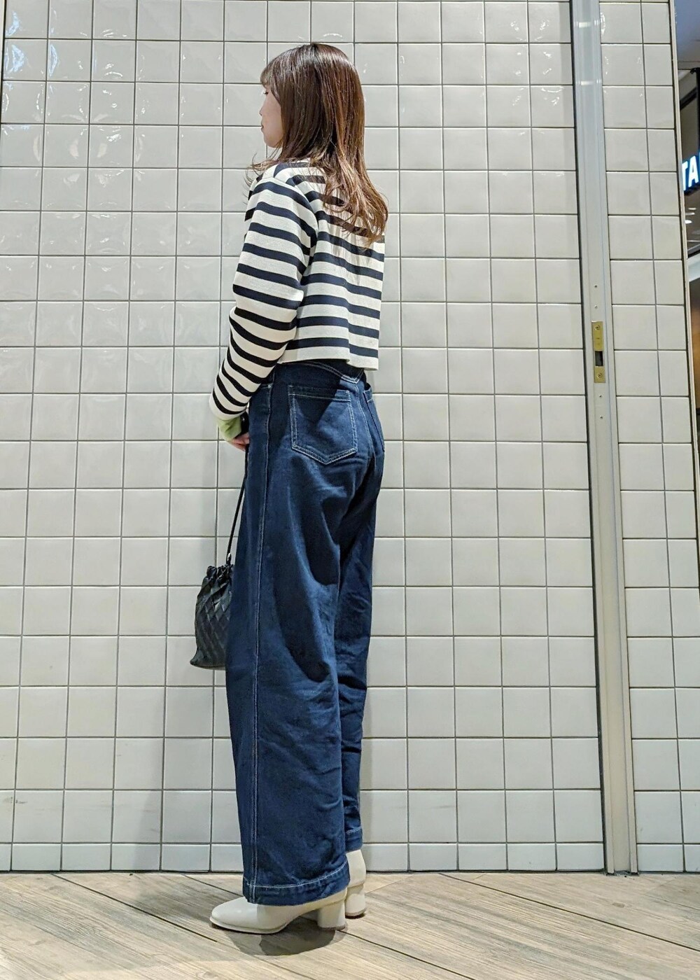 ホワイト系のカーディガン/ボレロ、グリーン系のTシャツ/カットソー、ブルー系のデニムパンツを着用したレディースの春コーディネートの3枚目の写真