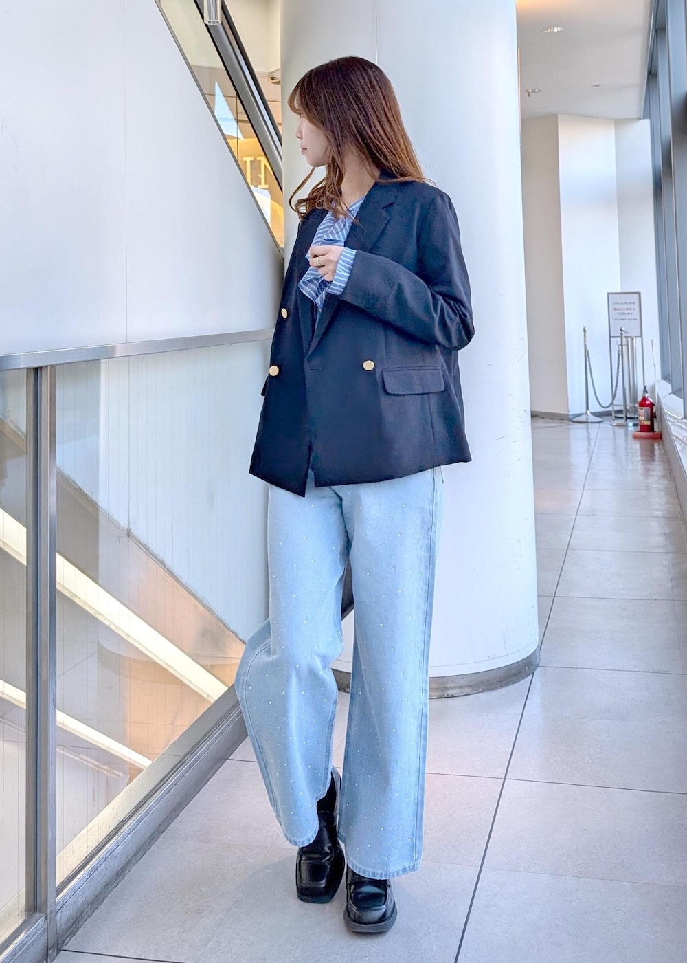 ブラック系のボストンバッグ、ブルー系のデニムパンツ、ブルー系のシャツ/ブラウスを着用したレディースの春コーディネートの6枚目の写真