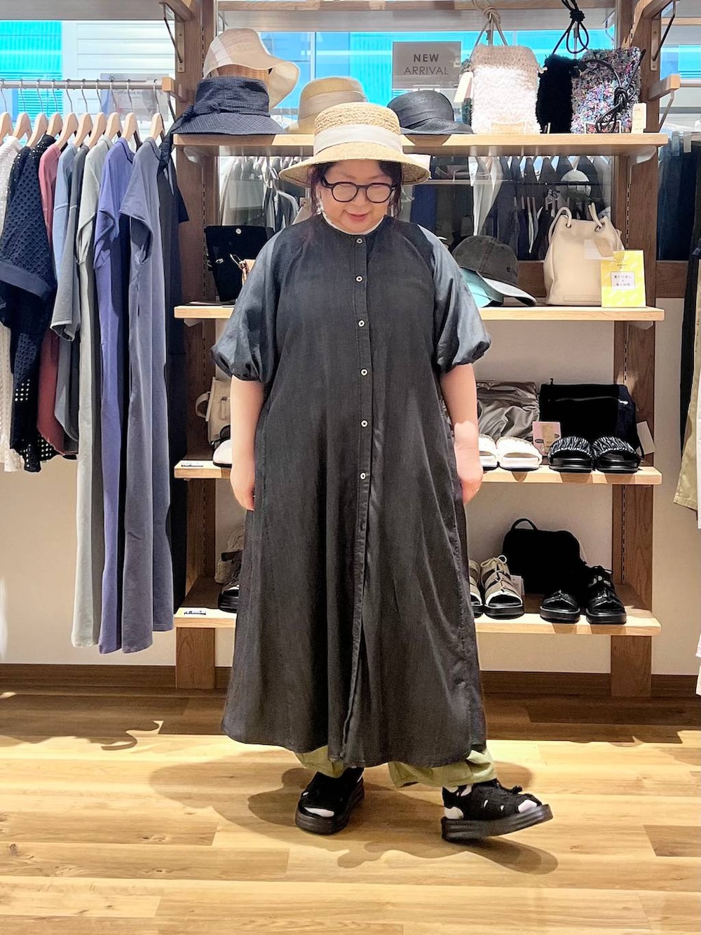 ブラック系のサンダル、グリーン系のその他パンツ、ブラック系のワンピースを着用したレディースの夏コーディネートの2枚目の写真