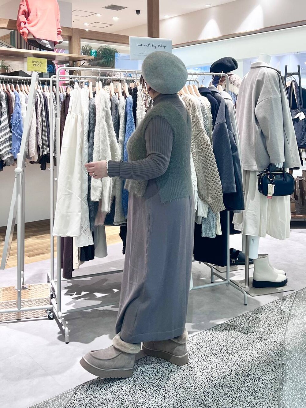 グレー系のブーツ、ベージュ系のショルダーバッグ、ブラウン系のワンピースを着用したレディースの冬コーディネートの8枚目の写真