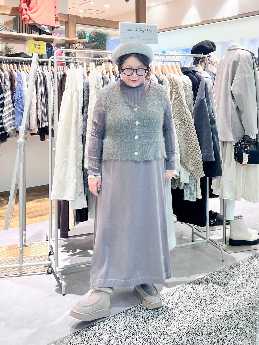 グレー系のブーツ、ベージュ系のショルダーバッグ、ブラウン系のワンピースを着用したレディースの冬コーディネートの7枚目の写真