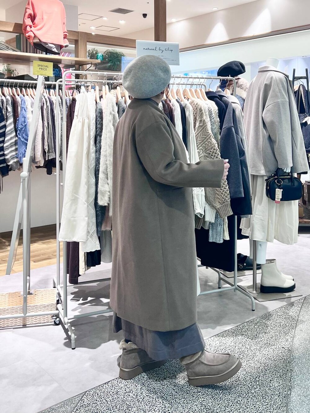 グレー系のブーツ、ベージュ系のショルダーバッグ、ブラウン系のワンピースを着用したレディースの冬コーディネートの3枚目の写真