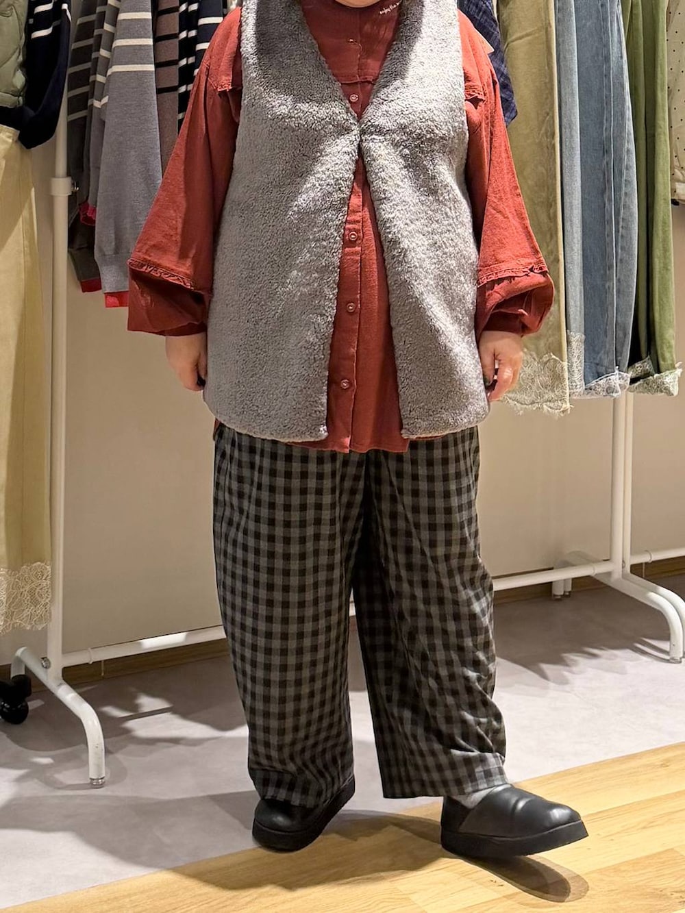 ブラック系のスリッポン、レッド系のシャツ/ブラウス、ブラック系のトートバッグを着用したレディースの秋コーディネートの5枚目の写真