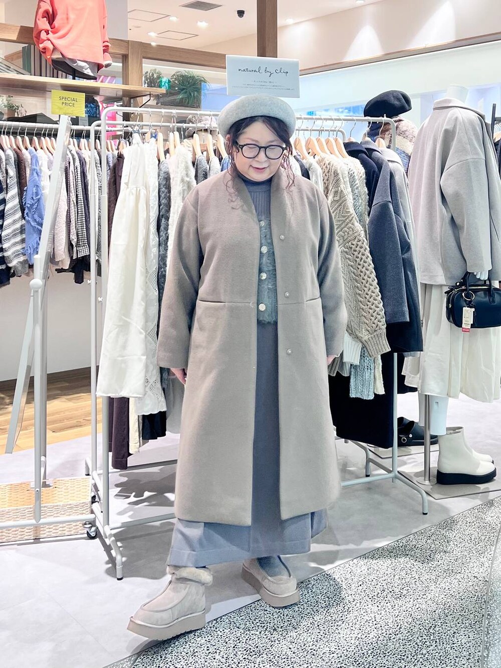 グレー系のブーツ、ベージュ系のショルダーバッグ、ブラウン系のワンピースを着用したレディースの冬コーディネートの2枚目の写真