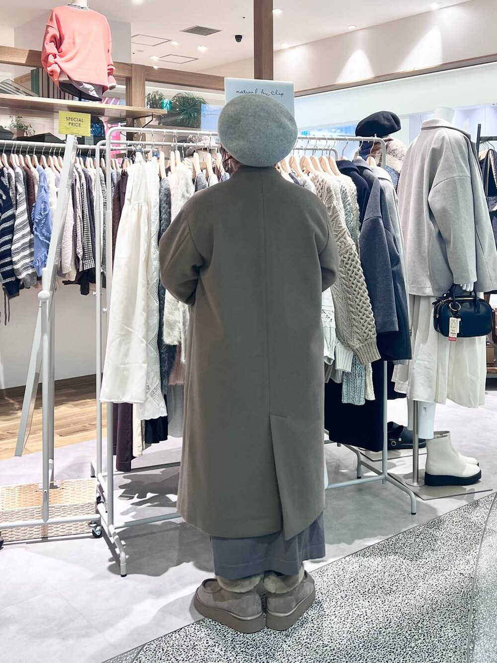 グレー系のブーツ、ベージュ系のショルダーバッグ、ブラウン系のワンピースを着用したレディースの冬コーディネートの4枚目の写真