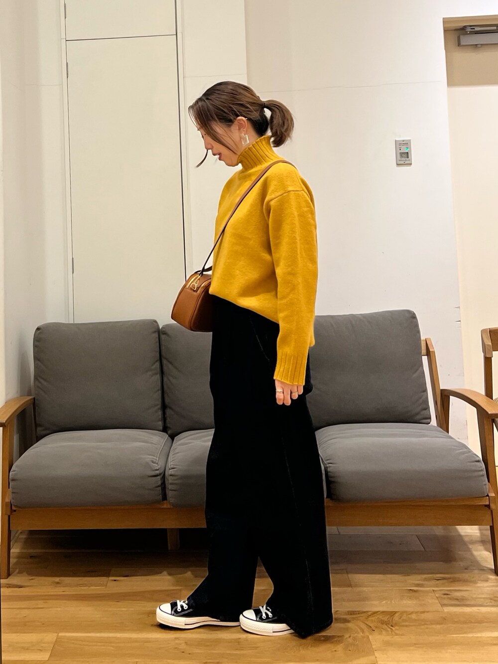 ブラウン系のその他アウター、イエロー系のニット/セーター、ブルー系のデニムパンツを着用したレディースの冬コーディネートの4枚目の写真