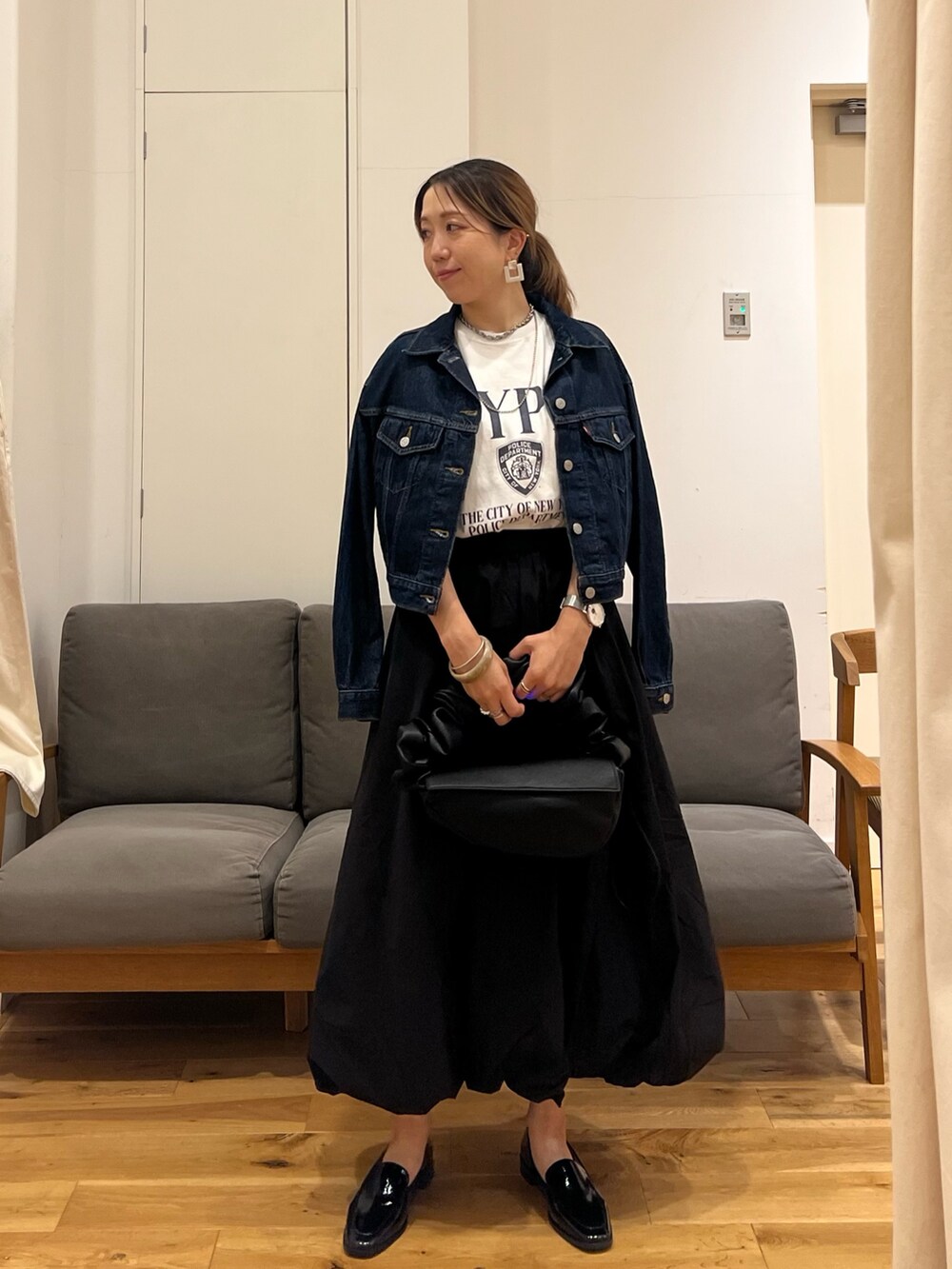 ブルー系のデニムジャケット、ホワイト系のTシャツ/カットソー、ブラック系のスカートを着用したレディースの夏コーディネートの4枚目の写真