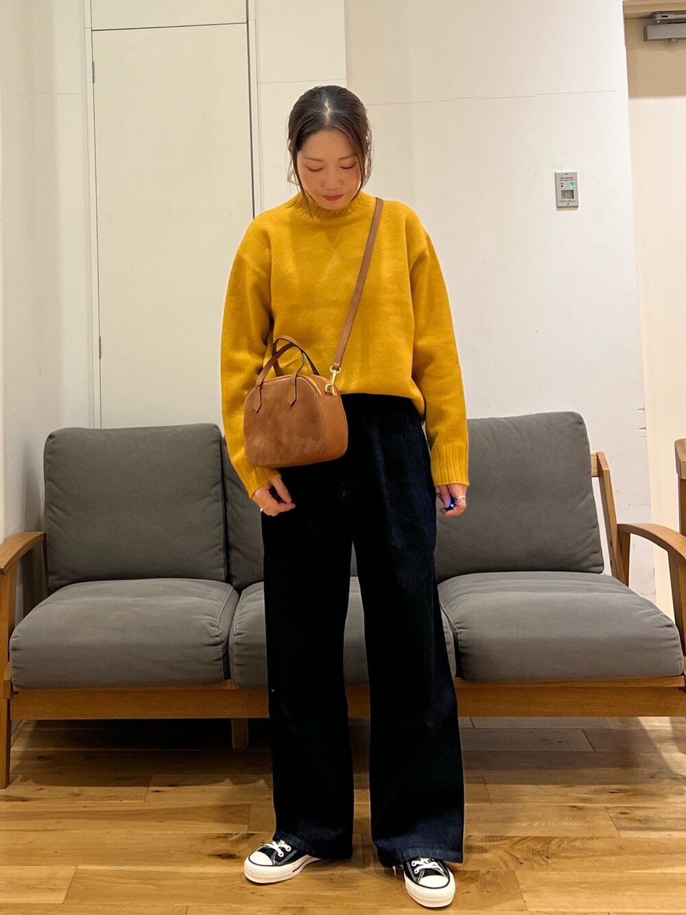 ブラウン系のその他アウター、イエロー系のニット/セーター、ブルー系のデニムパンツを着用したレディースの冬コーディネートの3枚目の写真