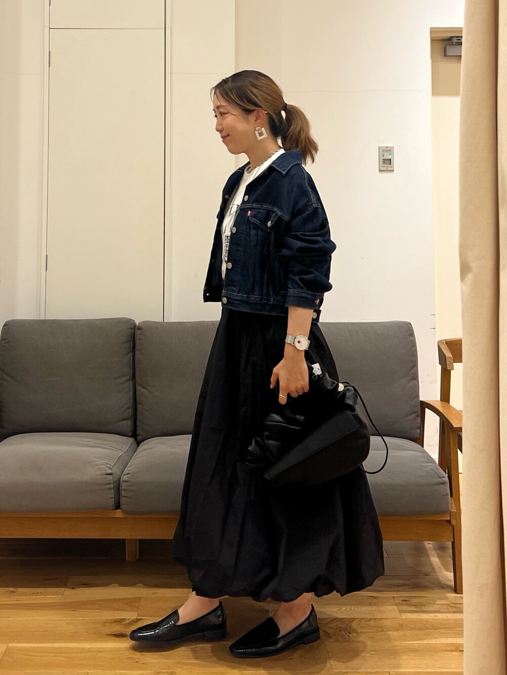 ブルー系のデニムジャケット、ホワイト系のTシャツ/カットソー、ブラック系のスカートを着用したレディースの夏コーディネートの3枚目の写真