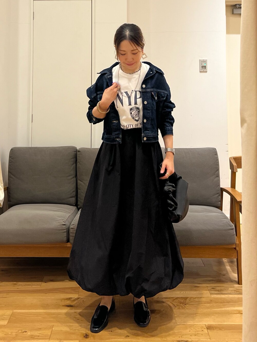 ブルー系のデニムジャケット、ホワイト系のTシャツ/カットソー、ブラック系のスカートを着用したレディースの夏コーディネートの2枚目の写真